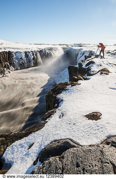 Fotografierender Mann am Rande des Selfoss-Wasserfalls im Winter  Schlucht  Nordisland  Island  Europa
