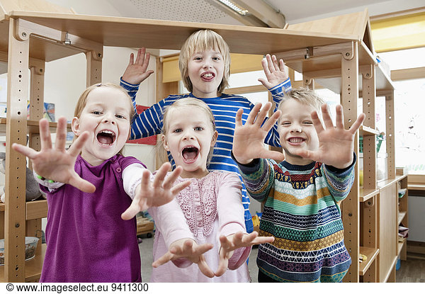 Four children with outstretched arms screaming