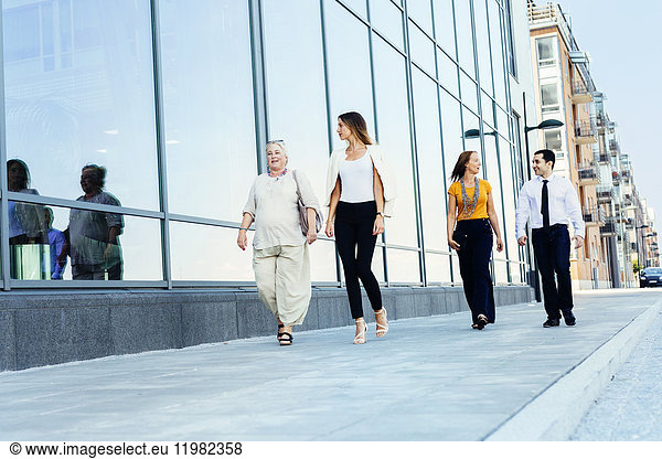 Four colleagues walking in city street
