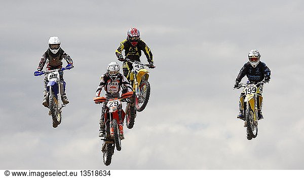 Four jumping motocross riders