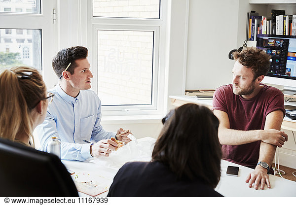 Four people at a business meeting around a table.