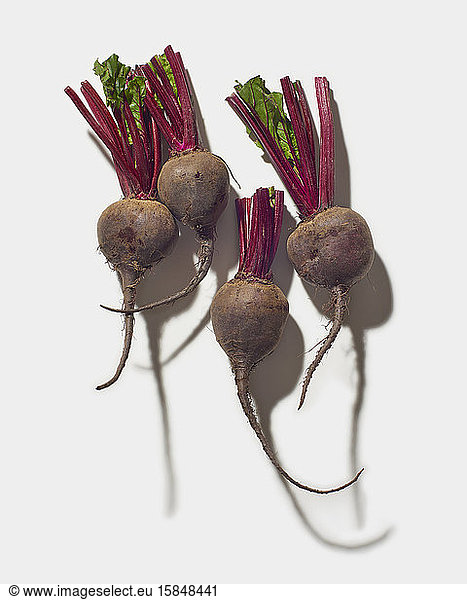 Four red beets on white