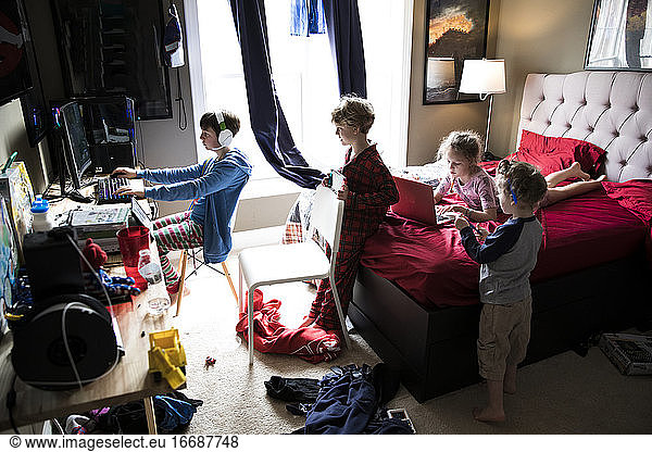 Four Siblings Hanging Out in Messy Teenage Brothers Bedroom