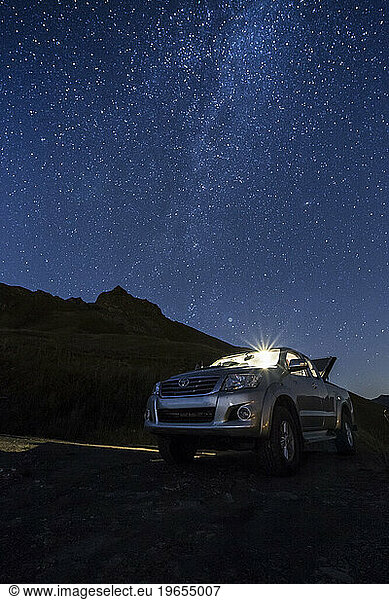 Four wheel drive pick up parked in French Alps during night with milky way above it  Saint Bernard pass  Savoie  France