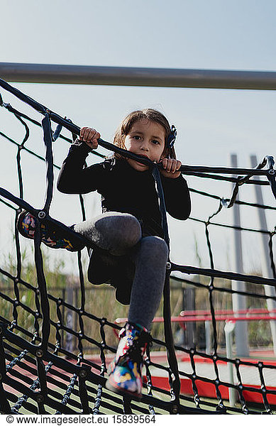 Four-year-old girl playing in the park  climbing in the daytime.