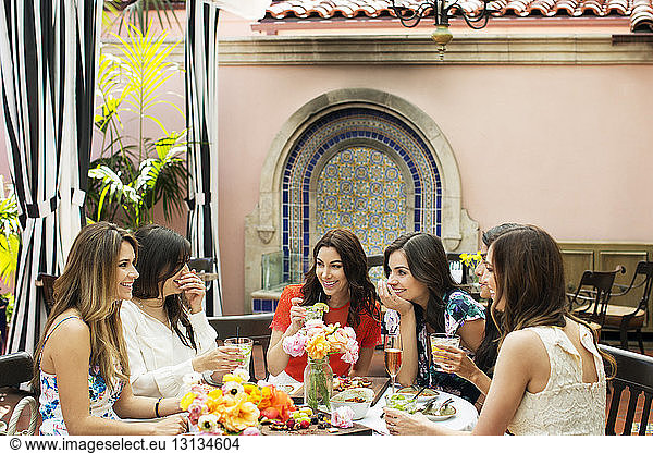 Fröhliche Frauen unterhalten sich im Außenrestaurant