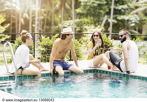 Fröhliche Freunde bei einem Drink am Pool