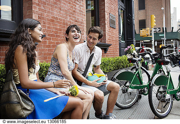 Fröhliche Freunde unterhalten sich im Straßencafé