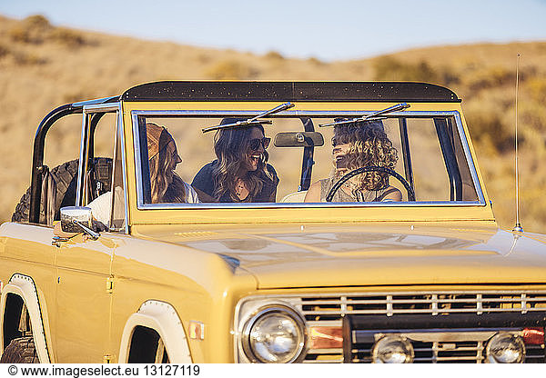 Fröhliche Freundinnen im Geländewagen bei Sonnenschein