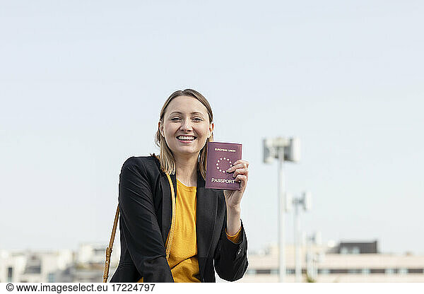 Fröhliche Geschäftsfrau zeigt Reisepass