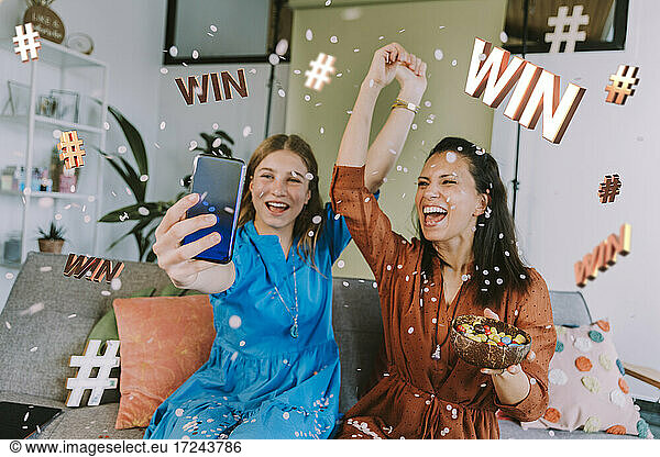 Fröhliche Influencerinnen werben für Gewinnspiele über das Mobiltelefon zu Hause