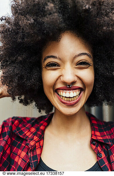 Fröhliche junge Frau mit Afro-Frisur und Nasenring