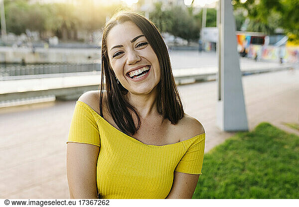 Fröhliche junge Frau verbringt ihre Freizeit im Park