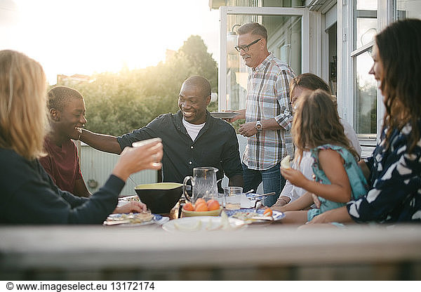 Fröhliche Mehrgenerationen-Familie genießt Mittagessen auf der Veranda