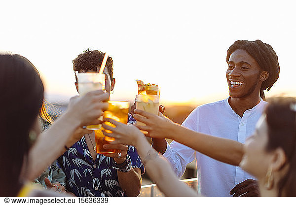 Fröhliche multi-ethnische Freunde stoßen auf Getränke an