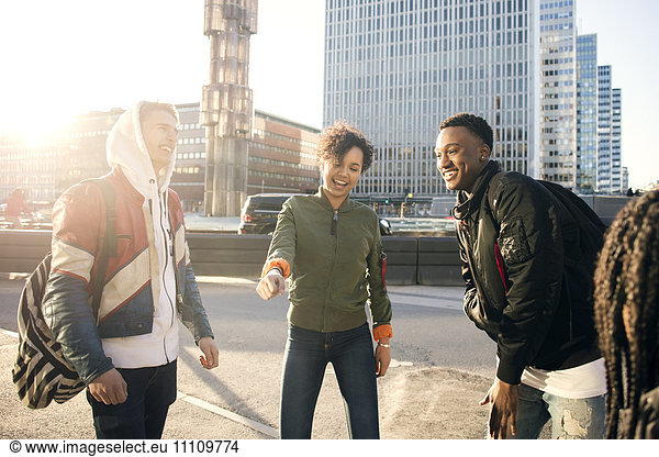 Fröhliche Teenager tanzen gegen Gebäude auf dem Stadtplatz