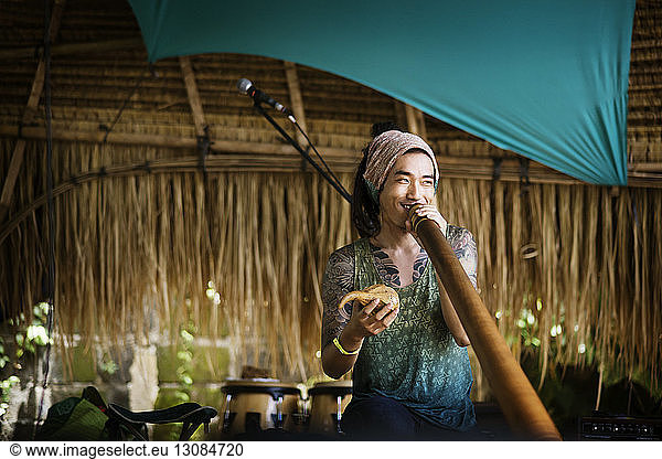 Fröhlicher Musiker spielt Alphorn während der Veranstaltung