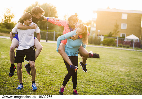 Fröhlichkeit Freundschaft Sonnenuntergang huckepack Sport
