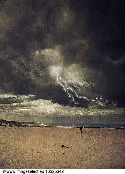 France, Contis-Plage, man standing at beach, thunderstorm and lightning, digitally manipulated