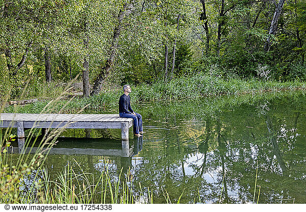 France  Alpes-de-Haute-Provence  Man sitting on pier by lake