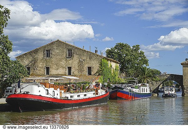 France  Aude  Saint Nazaire d'Aude  Canal du Midi listed as World Heritage by UNESCO  Port of Somail  barges of tourism alongside the quay with a bridge with background hogback