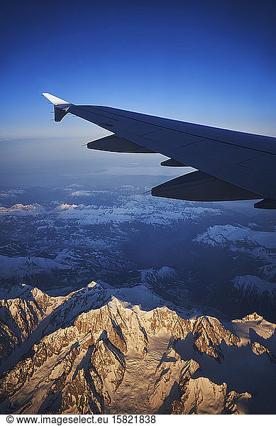 France  Auvergne-Rhone-Alpes  Wing of Airbus A321 flying over European Alps and Lake Geneva at dawn