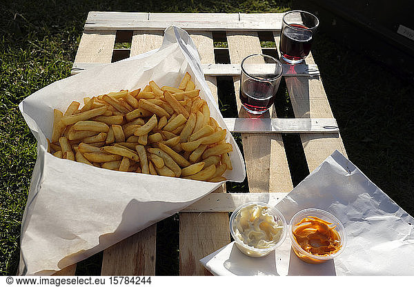 France  Brittany  Audierne  French fries with mayonnaise  ketchup and red wine - picnic on wooden crate