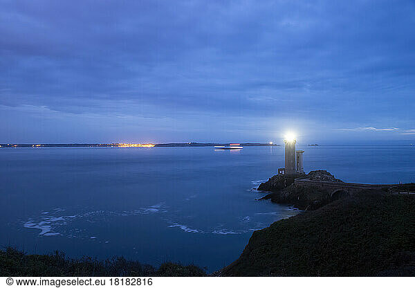 France  Brittany  Plouzane  Petit Minou Lighthouse glowing at cloudy dusk