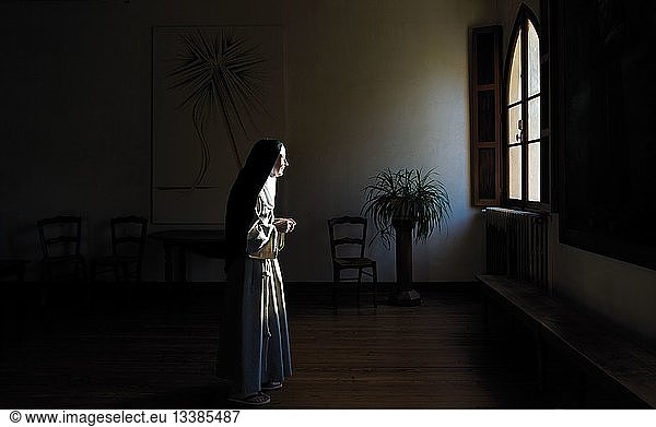 France  Haute Garonne  Toulouse  scene of a sister in the darkness illuminated by the light of a window