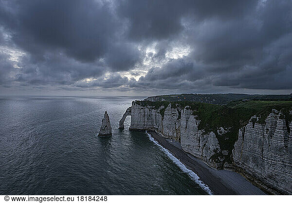 France  Normandy  Etretat  Falaise dAval cliffs and Aiguille dEtretat sea stack at cloudy dusk