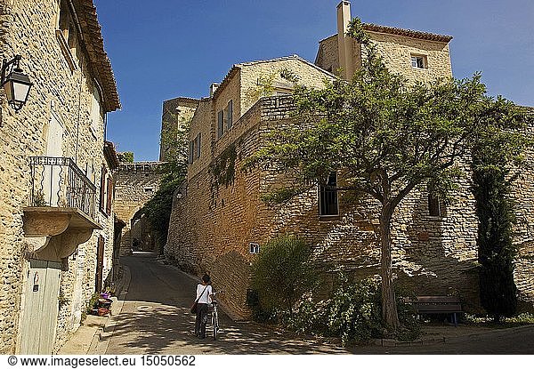 France  Vaucluse  Luberon  Goult  Woman with his bicycle in a lane in stone houses