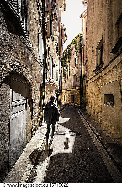 Frankreich Provence  Aix-en-Provence  Frau mit Hund beim Spaziergang auf der Straße