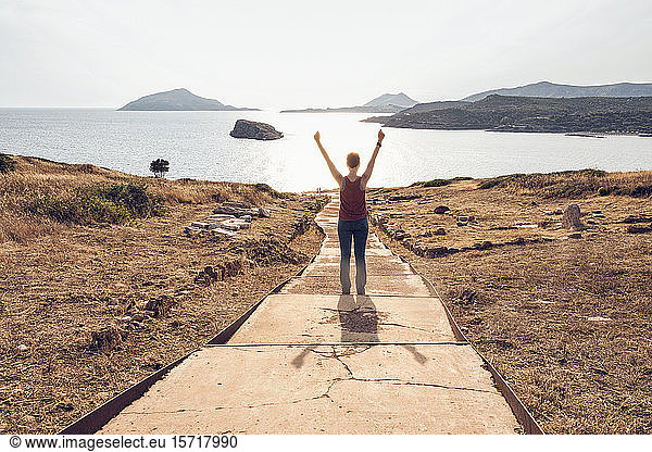 Frau am Kap Sountion stehend  mit erhobenen Armen  Rückenansicht  Attika  Griechenland