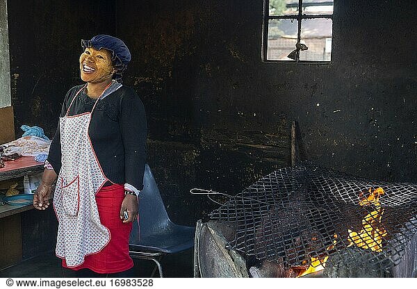 Frau bei der Zubereitung von shisa nyama (afrikanisches Barbecue) in einem Township  Johannesburg  Südafrika