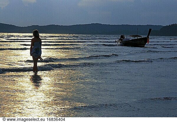 Frau bei Sonnenuntergang in Happy Island  Hat Phra Nang Beach  Railay  Provinz Krabi  Thailand  Südostasien  Asien. Der Hat Phra Nang Beach  Railay Beach  ist eines der schönsten Postkartenmotive von Thailand. Dieser Strand wird von einer Karstformation beherrscht  die sich an der Spitze der Halbinsel Railay über das Meer erhebt  und wird von kleinen Inseln geschmückt  die vom Meer aus auf ihn zu blicken scheinen.