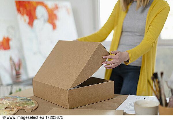 Frau beim Auspacken eines Kartons im Heimstudio