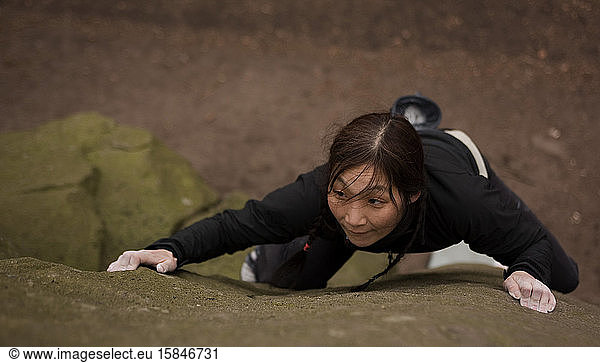 Frau beim Bouldern auf Gittersteinen im Peak District / UK