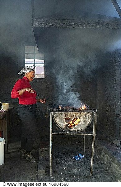 Frau beim Kochen von Shisa Nyama (afrikanisches Barbecue) in einem Township  Johannesburg  Südafrika