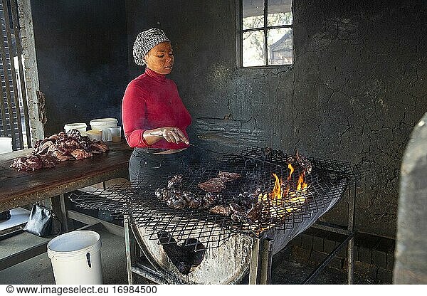 Frau beim Kochen von Shisenyama (afrikanisches Barbecue) in einem Township  Johannesburg  Südafrika
