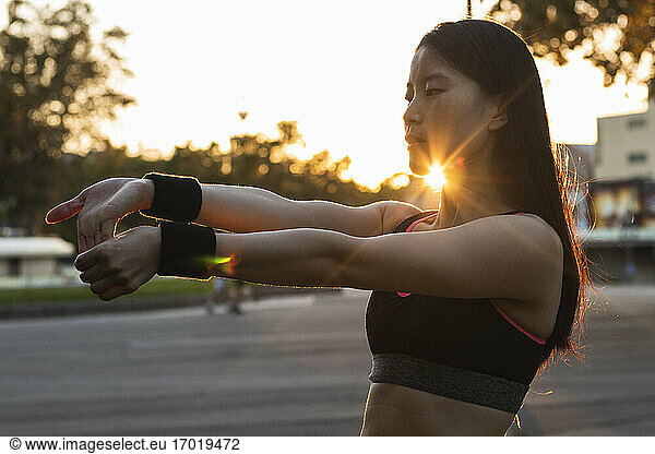 Frau beim Sport im Park bei Sonnenuntergang