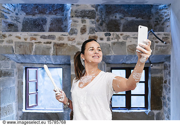 Frau beim Streichen der Wände ihres neuen Hauses