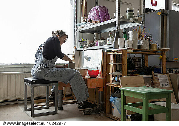Frau bereitet Ton in einer Werkstatt vor