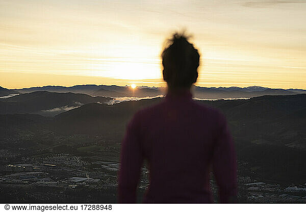 Frau betrachtet den Sonnenaufgang