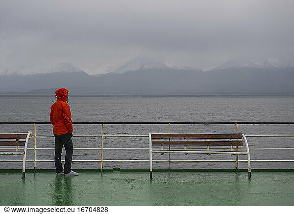 Frau blickt von einem Passagierschiff in Patagonien auf eine düstere Szenerie
