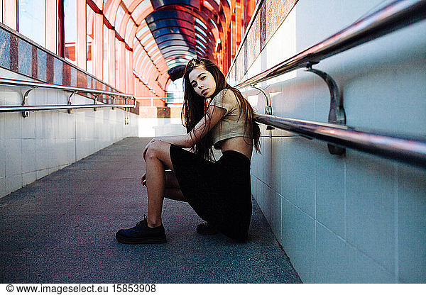 Frau  die in einem Tunnel mit Bögen sitzt