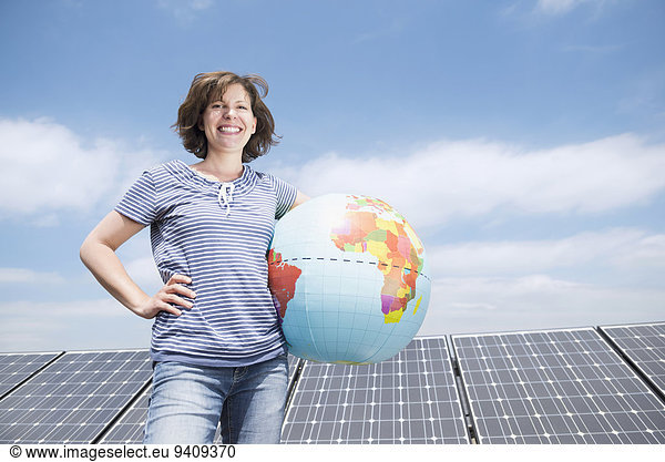 Frau Energie energiegeladen lächeln Sonnenkollektor Sonnenenergie Tisch Globus