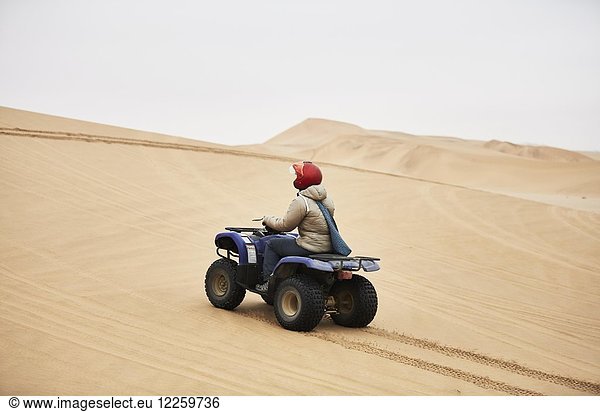 Frau fährt mit Quad über Sanddünen bei Swakopmund  Namibia  Afrika