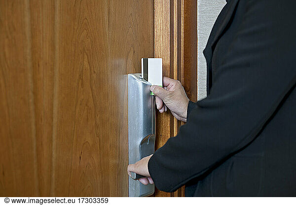 Frau öffnet Hotelzimmer mit magnetischer Schlüsselkarte