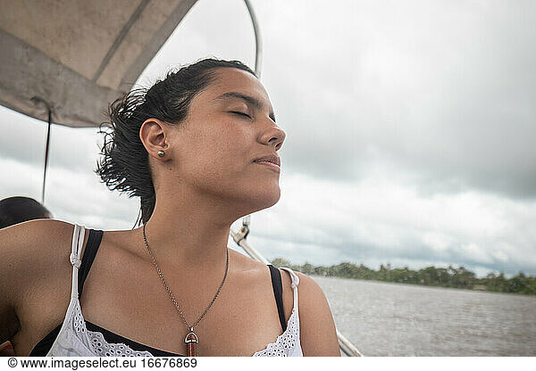 Frau findet sich mit geschlossenen Augen auf einem Sportboot während einer Kreuzfahrt wieder