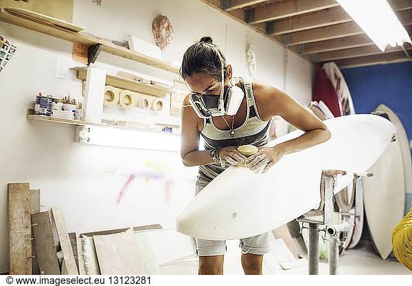 Frau formt Surfbrett beim Workshop